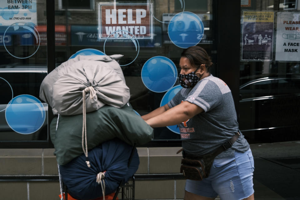 NEW YORK, NEW YORK - JUNE 04: People walk by a Help Wanted sign in the Queens borough of New York City on June 04, 2021 in New York City. The U.S. economy added 559,000 jobs in May, bringing the unemployment rate down to 5.8 percent from 6.1 percent. Despite the positive economic news, millions of Americans are still looking for work or are in need of financial, food, and housing assistance. (Photo by Spencer Platt/Getty Images)