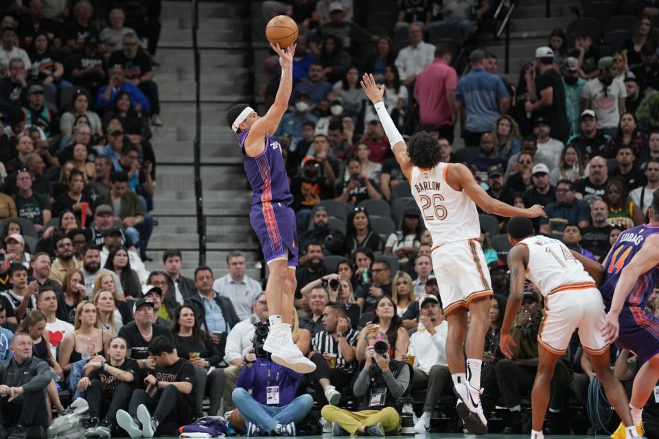 Phoenix Suns guard Devin Booker (1) shoots over San Antonio Spurs forward Dominick Barlow (26) in the first half at Frost Bank Center.