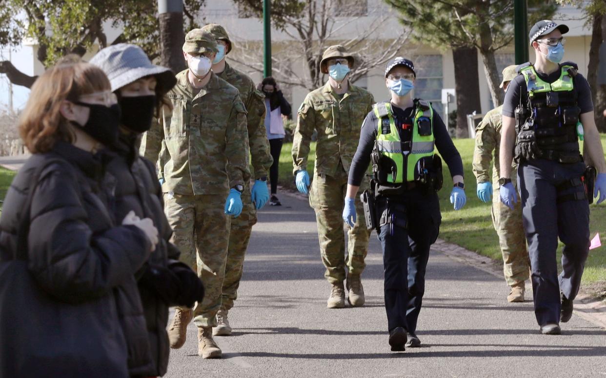 Australian Defence Force personnel and Victorian police officers patrol Fitzroy Gardens in Melbourne, Victoria - DAVID CROSLING/EPA-EFE/Shutterstock