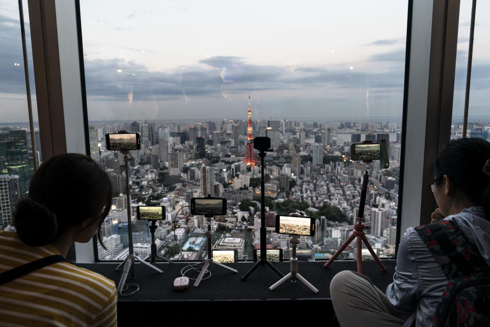 Smartphones are propped on tripods in the observation deck of the Mori Tower to capture Tokyo's skyline view in Tokyo, June 17, 2019. (AP Photo/Jae C. Hong)