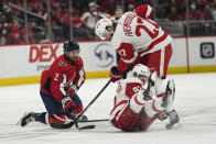 Washington Capitals defenseman Justin Schultz (2), Detroit Red Wings center Michael Rasmussen (27) and Detroit Red Wings center Vladislav Namestnikov (92) loose track of the puck as they collide in the first period of an NHL hockey game, Wednesday, Oct. 27, 2021, in Washington. (AP Photo/Alex Brandon)