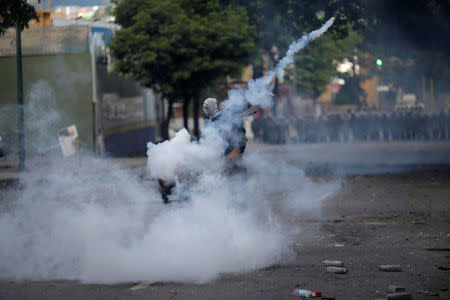 A demonstrator throws a tear gas canister at a rally during a strike called to protest against Venezuelan President Nicolas Maduro's government in Caracas, Venezuela July 26, 2017. REUTERS/Ueslei Marcelino