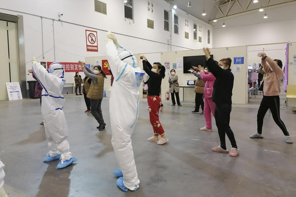 In this Feb. 18, 2020, photo released by Zhang Junjian, medical workers lead patients in exercises at the Wuhan Living Room Temporary hospital in Wuhan in central China's Hubei province. The hospital is the largest of 16 temporary hospitals set up in gyms and other locations to handle an overflow of patients and try to stem the spread of the coronavirus by separating them from the rest of the city's 11-million inhabitants. (Zhang Junjian via AP)