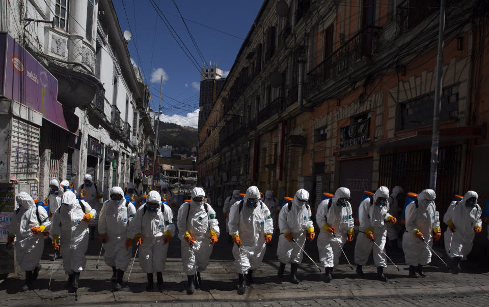 City workers fumigate a street to help contain the spread of the new coronavirus in La Paz, Bolivia, Thursday, April 2, 2020. (AP Photo/Juan Karita)
