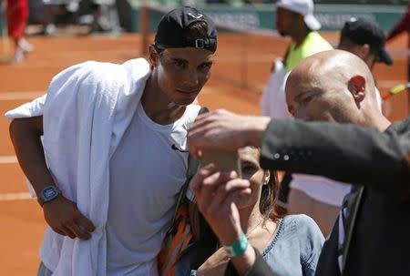 Rafael Nadal of Spain poses for selfies after a training session for the French Open tennis tournament at the Roland Garros stadium in Paris, France, May 22, 2015. REUTERS/Vincent Kessler