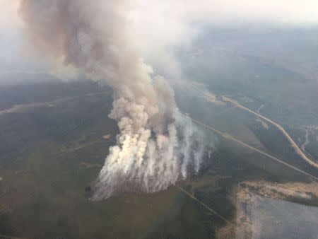 Smoke rises from a wildfire east of Slave Lake, Alberta May 25, 2015 in a photo supplied by the Alberta Wildfire Info department. REUTERS/Alberta Environment and Sustainable Resource Development (ESRD)/handout via Reuters