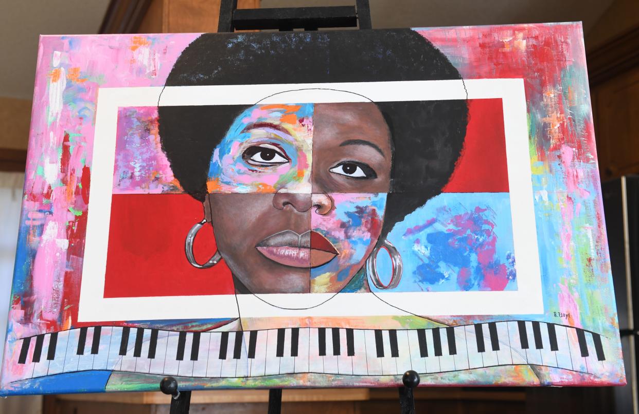 Raymond Floyd was a Spartanburg artist and art teacher. He was the first Black art educator in Spartanburg District 7. He passed away Nov. 21 at 82. Heather Mitchell shows off one of her father's paintings of famous people, this one is of Nina Simone.