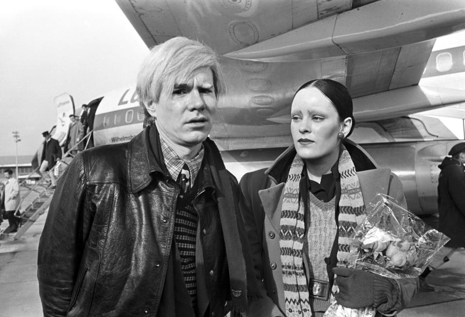 <p>Andy Warhol and actress Jane Forth are photographed upon their arrival in Munich, Germany in 1971. Warhol was visiting for the premiere of his film <em>Trash</em>. </p>