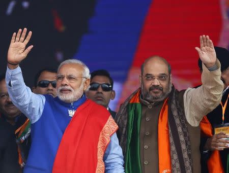 Indian Prime Minister Narendra Modi (L) and Amit Shah, the president of India's ruling Bharatiya Janata Party (BJP), wave to their supporters during a campaign rally ahead of state assembly elections, at Ramlila ground in New Delhi January 10, 2015. REUTERS/Anindito Mukherjee