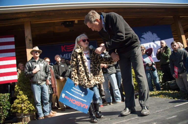 Republican presidential candidate John Kasich (R) speaks with a young supporter during a campaign rally outside Mutt's BBQ in Mauldin, South Carolina on February 13, 2016