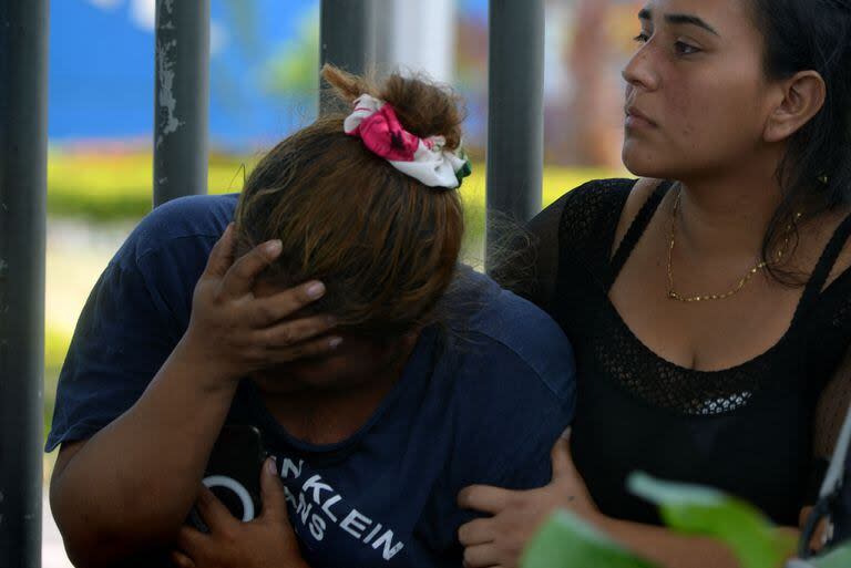 Una mujer gesticula mientras espera el cuerpo de una de las víctimas del tiroteo de la víspera en una cooperativa, frente al Laboratorio de Criminalística y Ciencias Forenses, en Guayaquil, Ecuador, el 31 de marzo de 2024. 