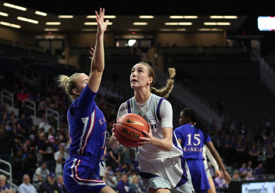 Kansas State point guard Serena Sundell (4) takes the ball to the basket against Kansas' Sanna Strom during their Sunflower Showdown game Wednesday night at Bramlage Coliseum.