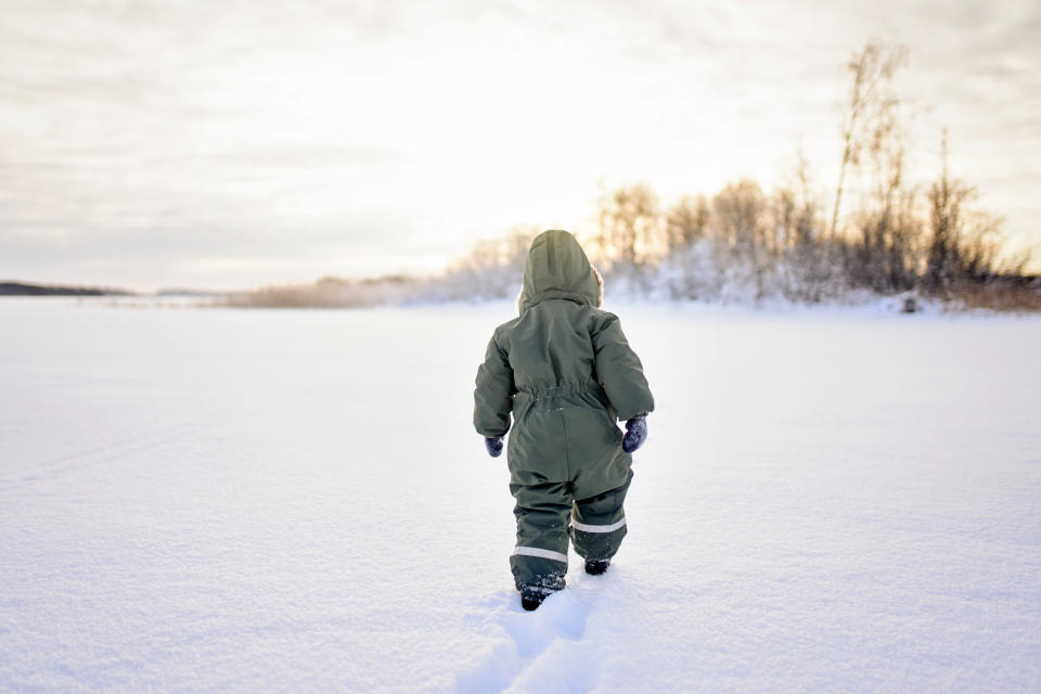 A young boy walking in snow