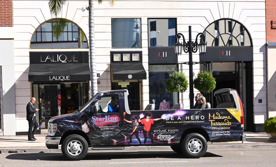 A sightseeing tour cruises past shops on Rodeo Drive in Beverly Hills in 2019.