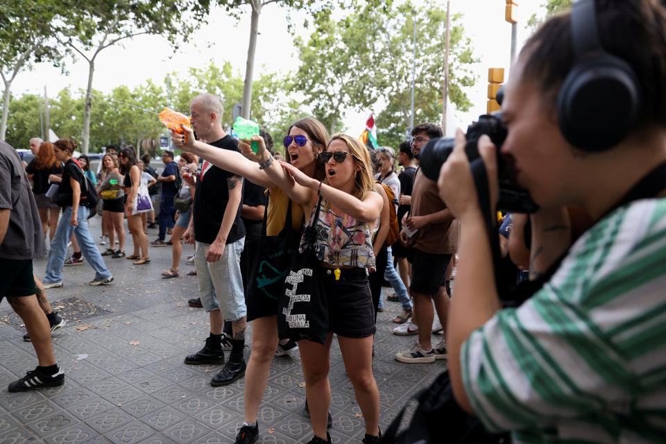 Protesters shoot water from water guns at tourists during a protest against mass tourism in Barcelona.