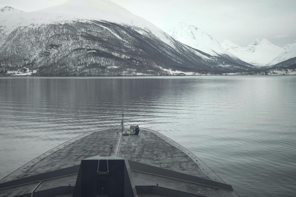 A French sailor sits at the bow of the French navy frigate Normandie during a patrol in a Norwegian fjord, north of the Arctic circle, Friday March 8, 2024. The French frigate is part of a NATO force conducting exercises in the seas, north of Norway, codenamed Steadfast Defender, which are the largest conducted by the 31 nation military alliance since the cold war. (AP Photo/Thibault Camus)