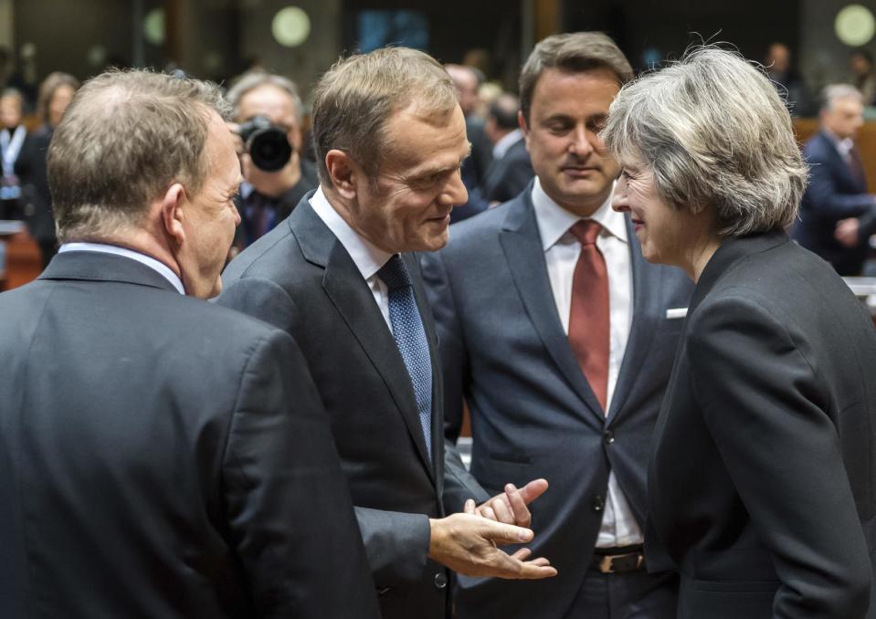 European Council President Donald Tusk, second left, speaks with British Prime Minister Theresa May, right, during a round table meeting at an EU Summit in Brussels on Thursday, Dec. 15, 2016. European Union leaders meet Thursday in Brussels to discuss defense, migration, the conflict in Syria and Britain's plans to leave the bloc. At left is Danish Prime Minister Lars Lokke Rasmussen, and second right is Luxembourg's Prime Minister Xavier Bettel. (AP Photo/Geert Vanden Wijngaert)