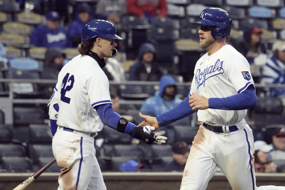 Kansas City Royals' Hunter Dozier, right, celebrates with Bobby Witt Jr. after scoring on a double by Jackie Bradley Jr. during the sixth inning of a baseball game against the Atlanta Braves Saturday, April 15, 2023, in Kansas City, Mo. (AP Photo/Charlie Riedel)