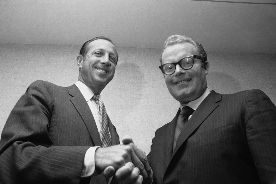 FILE - In this May 1969 file photo, NFL Commissioner Pete Rozelle, left, and Roone Arledge, president of ABC Sports, shake hands in New York, where it was announced that ABC would televise 13 regular-season games on Monday nights. Pete Rozelle would not be surprised to see the NFL’s impact of television as it celebrates its 100th season this year. It was Rozelle, the commissioner from 1960 to 1989, who was able to convince owners that it was in their best interest to sign a leaguewide rights deal instead of teams negotiating on their own. (AP Photo/File)