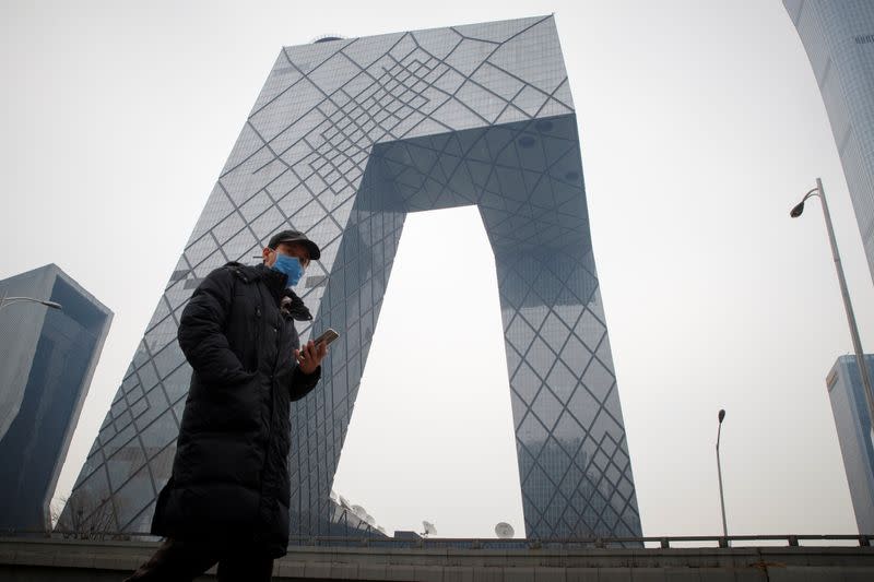 A man wears a face mask as he crosses a street in the Central Business District in Beijing as the country is hit by an outbreak of the novel coronavirus