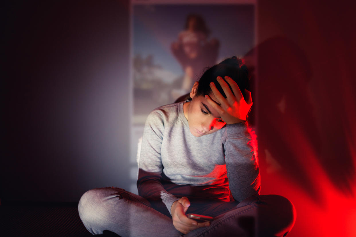 Young woman feeling stressed while looking at her phone