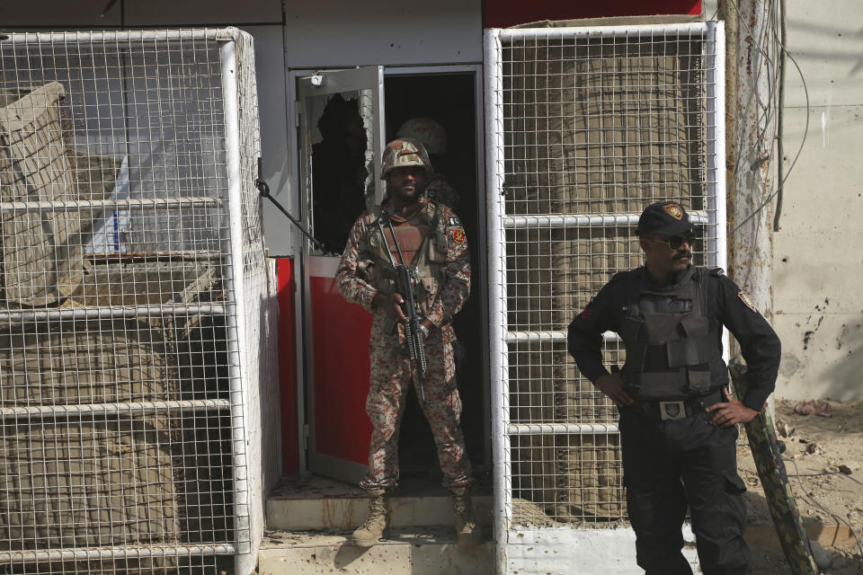 Pakistani security personnel stand guard at an entrance of the Chinese Consulate in Karachi, Pakistan, Friday, Nov. 23, 2018. Pakistani police say gunmen have stormed the Chinese Consulate in the country's southern port city of Karachi, triggering an intense shootout. (AP Photo/Shakil Adil)