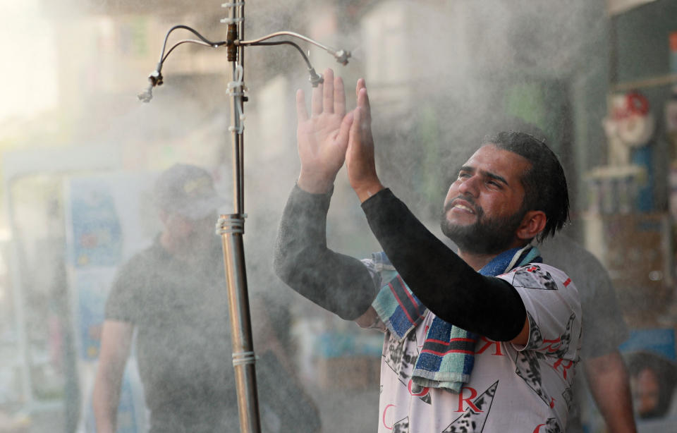 A man cools off from the summer heat under an open air shower in Baghdad, Iraq, Sunday, July 5, 2020. (AP Photo/Hadi Mizban)