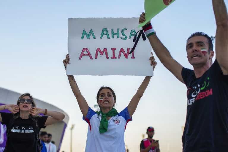 Una mujer sostiene un cartel con el nombre de Mahsa Amini, una mujer que murió mientras estaba detenida por la policía en Irán, durante una protesta después del un partido del Grupo B del Mundial entre Gales e Irán, en el estadio Ahmad Bin Ali en Rayán, Qatar
