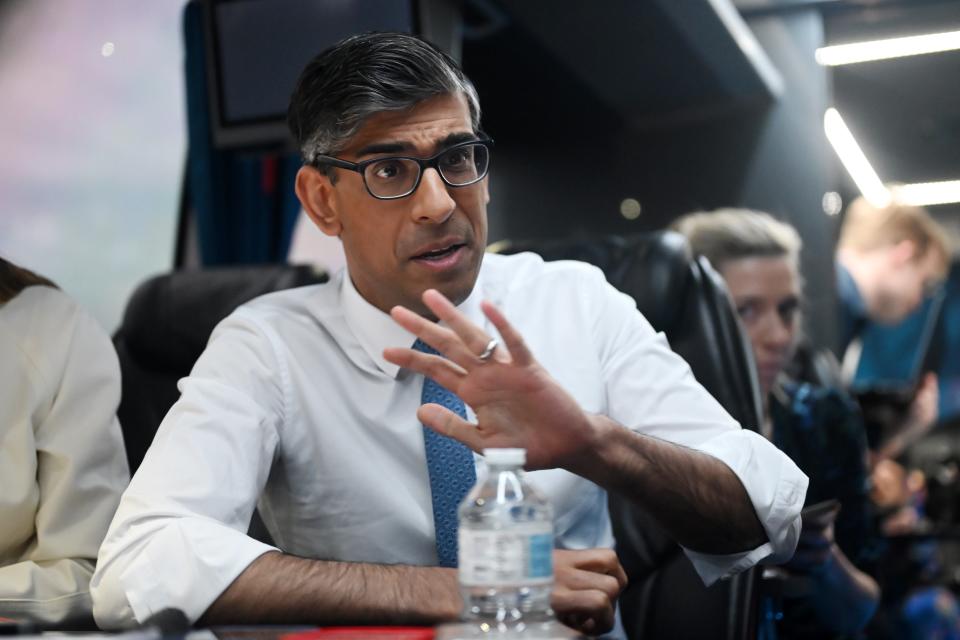 Rishi Sunak speaks to journalists on a campaign bus as he travelled to Wales on Friday (Getty Images)