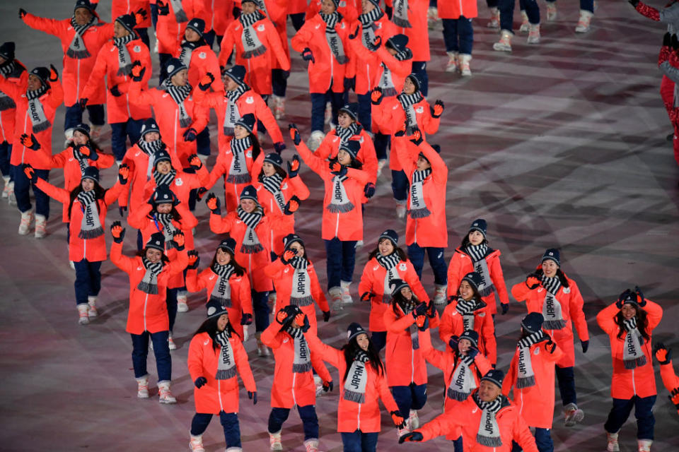 <p>Flag bearer Sara Takanashi of Japan and teammates wear red zip jackets, navy pants, and “Japan” gray scarves when entering the stadium during the opening ceremony of the 2018 PyeongChang Games. (Photo: Pool — Frank Fife/Getty Images) </p>