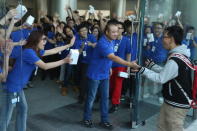 Chinese Apple staff members greet customers as they enter the new Apple Store in Wangfujing shopping district on October 20, 2012 in Beijing, China. Apple Inc. opened its sixth retail store on the Chinese mainland Saturday. The new Wangfujing store is Apple's largest retail store in Asia. (Photo by Feng Li/Getty Images)