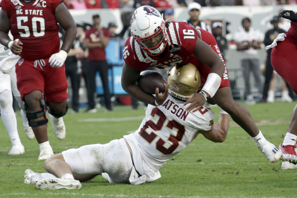 North Carolina State quarterback MJ Morris (16) is tackled by Boston College defensive back Cole Batson (23) during the first half of an NCAA college football game Saturday, Nov. 12, 2022, in Raleigh, N.C. (AP Photo/Chris Seward)