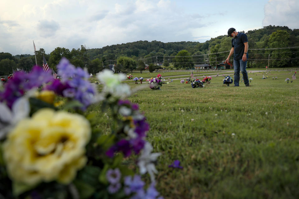 FILE - In this July 17, 2019 file photo Eddie Davis steps up to the gravestone of his son Jeremy, who died from the abuse of opioids in Coalton, Ohio. Jury selection is set to begin Wednesday, Oct. 16, 2019, in the first federal trial over the nation's opioid epidemic. The trial focuses on lawsuits filed by two Ohio counties claiming drug companies that made, distributed and sold prescription painkillers engaged in a deadly conspiracy that has inflicted massive damage on their communities. (AP Photo/John Minchillo, File)