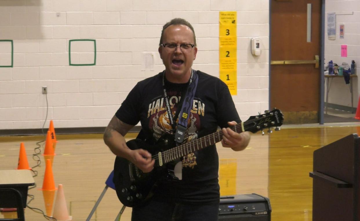 Music Teacher Gus Carlson leads students in a song about kindness.