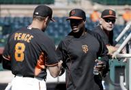 San Francisco Giants former player Barry Bonds, right, shakes hands with right fielder Hunter Pence during batting practice before a spring training baseball game between the Giants and the Chicago Cubs in Scottsdale, Ariz., Monday, March 10, 2014. Bonds starts a seven day coaching stint today. (AP Photo/Chris Carlson)