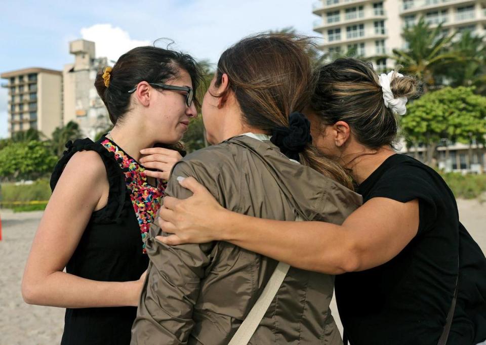 From left to right, Fayzah Bushnaq, Maria Fernanda Martinez and Mariana Cordeiro comfort each other next to the Champlain Towers South Condo in Surfside, Florida, Friday, June 25, 2021. The apartment building partially collapsed on Thursday, June 24.