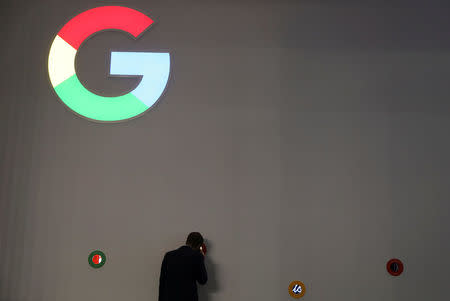 A man checks Google devices outside its booth at the Mobile World Congress in Barcelona, Spain, February 27, 2018. REUTERS/Sergio Perez