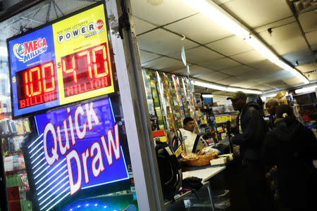 Signs display the jackpots for Mega Millions and Powerball lottery drawings as customers line up at a store in midtown Manhattan in New York, U.S., October 19, 2018. REUTERS/Mike Sugar