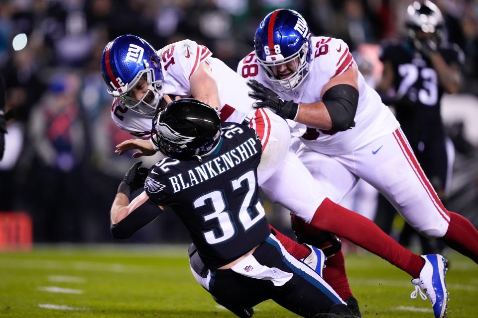 New York Giants quarterback Davis Webb (12) plows over Philadelphia Eagles safety Reed Blankenship (32) while scoring on a touchdown run during the second half of an NFL football game, Sunday, Jan. 8, 2023, in Philadelphia. Giants guard Ben Bredeson (68) helps on the play. (AP Photo/Matt Rourke)