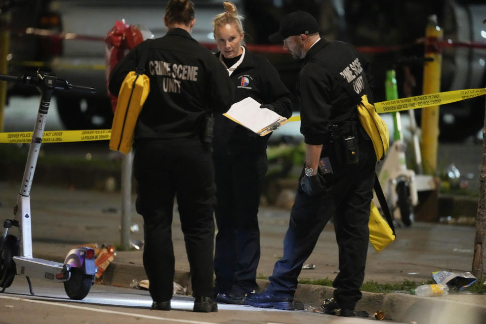 Denver Police Department investigators work the scene of a mass shooting early Tuesday, June 13, 2023, in Denver. Police say several people were wounded in an area where basketball fans had been celebrating the Denver Nuggets first NBA title win. A man who is a suspect was one of the people shot and was taken into custody. (AP Photo/David Zalubowski)