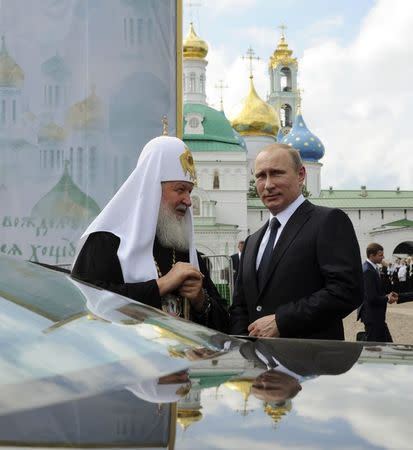 Russian President Vladmir Putin (R) visits the Trinity Lavra monastery with Kirill, Patriarch of Moscow and All Russia, in Sergeiv Posad in the Moscow region in this July 18, 2014 file photo. REUTERS/Mikhail Klimentyev/RIA Novosti/Kremlin/Files