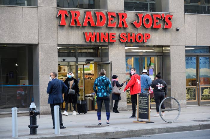 People outside Trader Joe's Wine Shop with a sandwich board sign