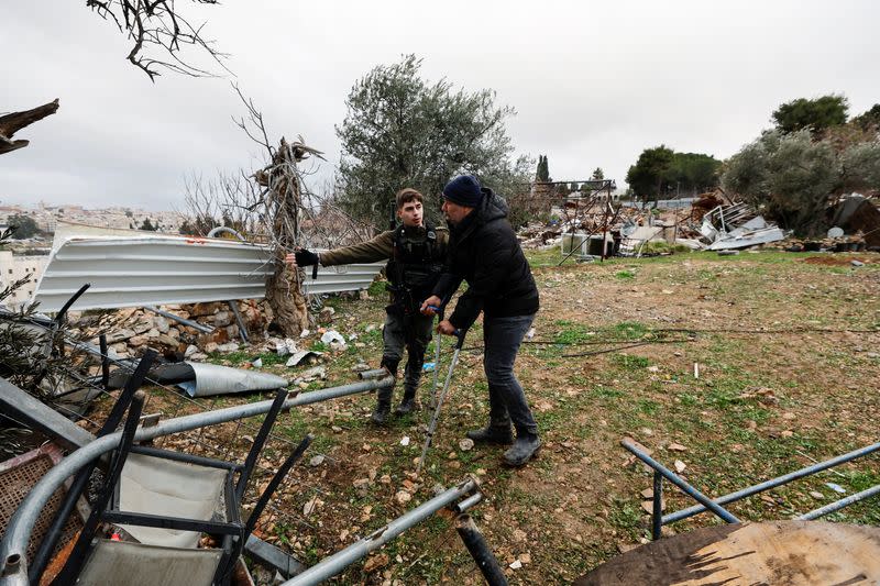 A member of the Israeli border police speaks with a Palestinian man at the site of a demolished house in the Sheikh Jarrah neighbourhood of East Jerusalem