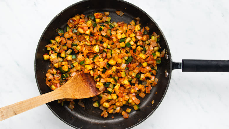 Tomatoey diced veg frying in pan