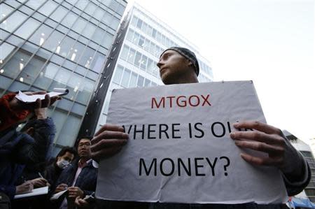 Kolin Burges, a self-styled cryptocurrency trader and former software engineer from London, holds a placard to protest against Mt. Gox, in front of the building where the digital marketplace operator was formerly housed in Tokyo February 26, 2014. REUTERS/Toru Hanai
