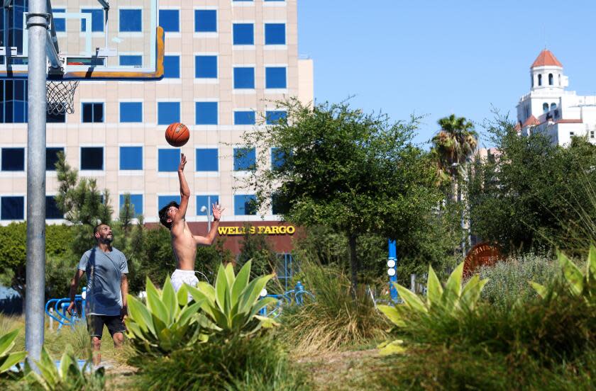 LONG BEACH-CA-JULY 3, 2024: Two men play a game of basketball at Lincoln Park in Long Beach on July 3, 2024. (Christina House / Los Angeles Times)