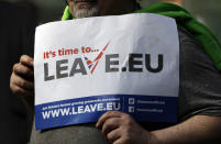 FILE - In this Thursday, March 31, 2016 file photo, a 'Leave' supporter holds a banner near the Electoral Commission, in London. Five years ago, Britons voted in a referendum that was meant to bring certainty to the U.K.’s fraught relationship with its European neigbors. Voters’ decision on June 23, 2016 was narrow but clear: By 52 percent to 48 percent, they chose to leave the European Union. It took over four years to actually make the break. The former partners are still bickering, like many divorced couples, over money and trust. (AP Photo/Kirsty Wigglesworth, File)