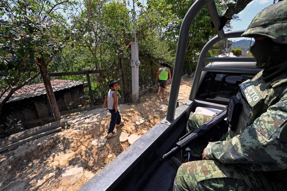 Soldados mexicanos pasan frente a la comunidad de San Vicente, en el municipio de Atoyac de Álvarez, en el estado de Guerrero, México el 2 de marzo de 2023. (Foto de ALFREDO ESTRELLA/AFP vía Getty Images)