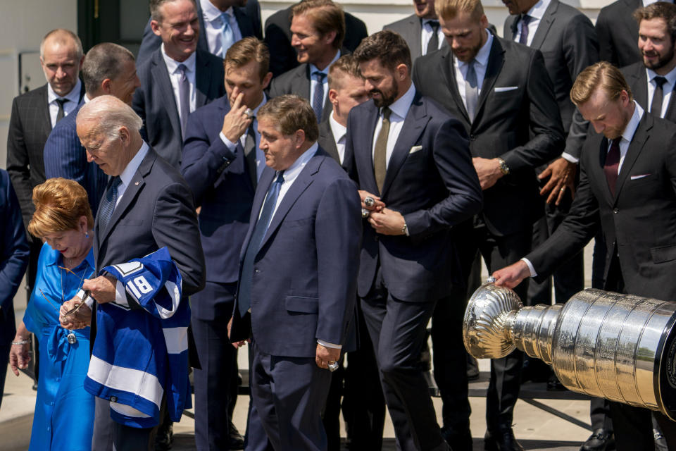 Tampa Bay Lightning captain Steven Stamkos, right, carries the Stanley Cup behind President Joe Biden, second from left, owner Jeff Vinik, center left, and his wife Penny, left, and other members of the team following an event to celebrate the Tampa Bay Lightning's 2020 and 2021 Stanley Cup championships at the White House in Washington, Monday, April 25, 2022. (AP Photo/Andrew Harnik)