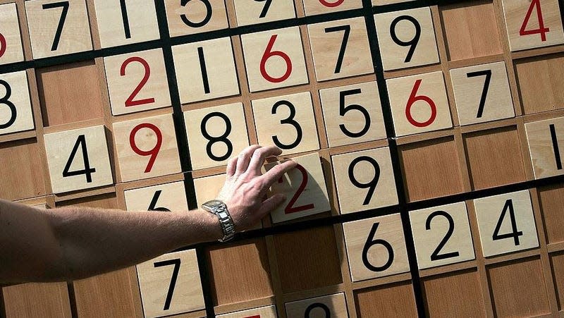 A person playing Sodoku on a giant board